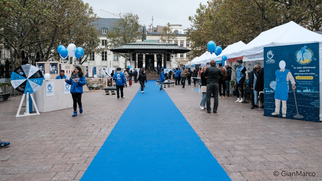 Un tapis bleu au sol avec des stands sur les deux côtés