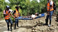 Des bénévoles portent une femme handicapée lors d’un exercice de simulation de catastrophe naturelle, à Haïti.
