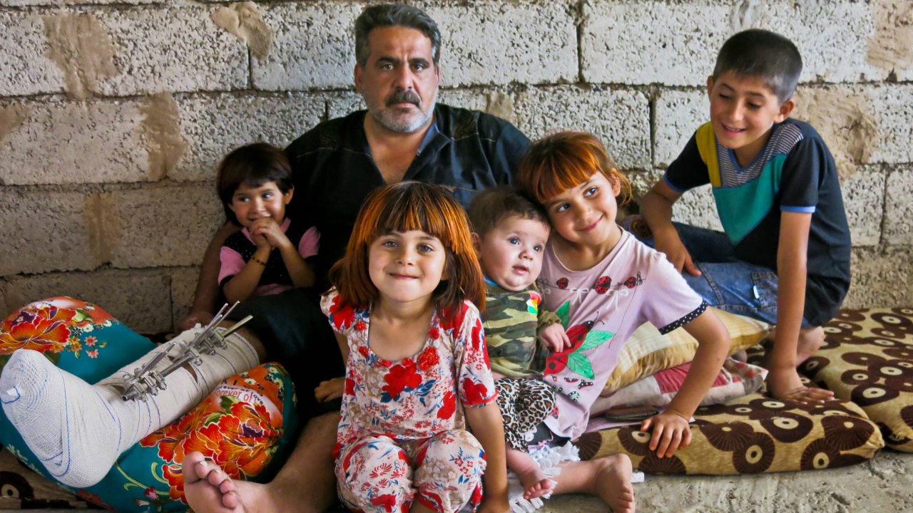 Saadi, accompagné de ses enfants, dans le logement de fortune qu’ils occupent désormais dans la région de Kirkouk.