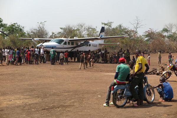 Eines der von uns unterstützten Flugzeuge. Viele Menschen stehen außen rum.