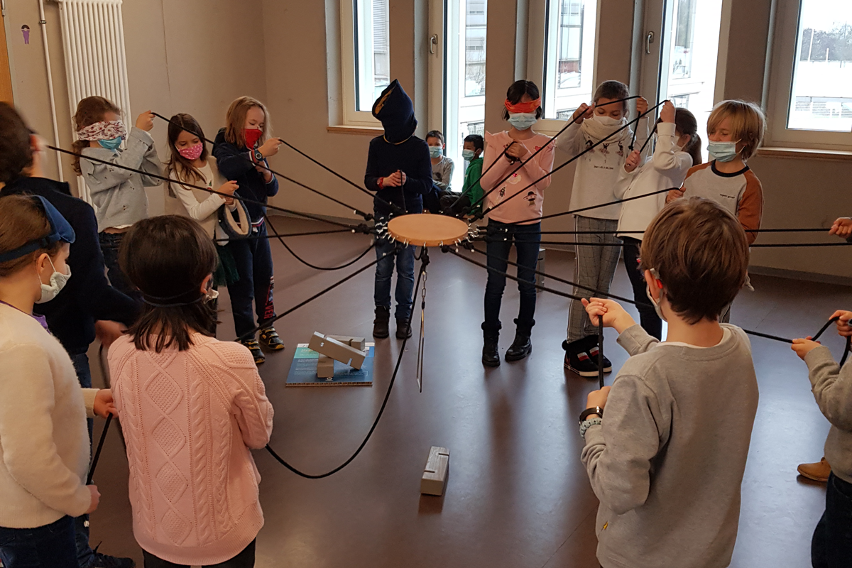 Des enfants en cercle tenant des cordes à la main