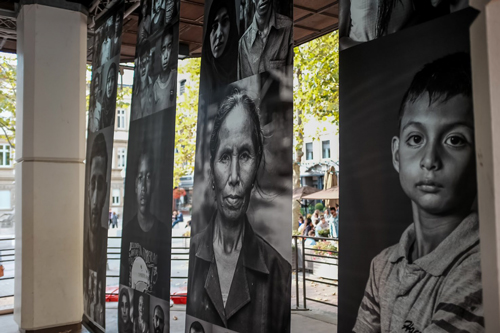 Des panneaux montrant des visages d'hommes et de femmes en noir et blanc