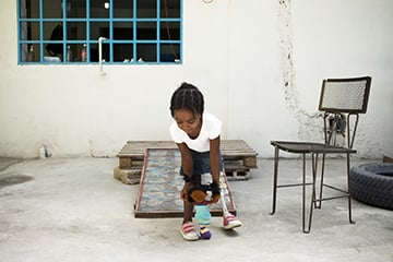 Fymée jouant avec sa poupée elle-même amputée, centre d'appareillage, Port au Prince. Haïti.