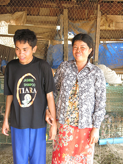 -	Madame Kim Leng Ros, avec son fils Bory, atteint d’autisme, qui peut élever des poulets tout en s’occupant de son fils