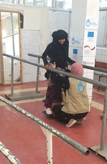 Au yémen, Heba fait des exercices d'équilibre avec sa kiné de HI.