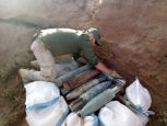 Simon dispose les armes collectées qui sont destinées à être détruites 