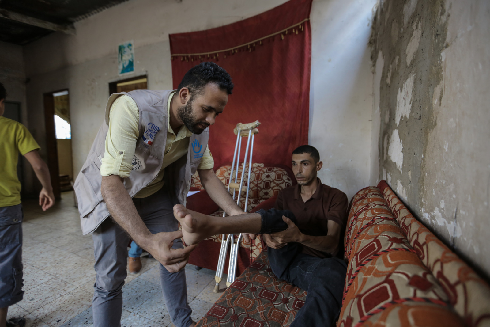 Un kinésithérapeute de HI ausculte la jambe d’Alaa 