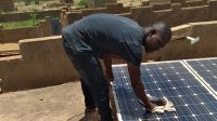 Dicko répare un panneau solaire au Mali, 2020