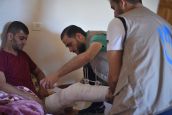 Un kinésithérapeuthe de HI auprès d'un patient 