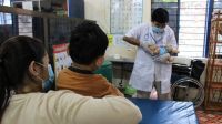 Pendant l'épidémie de Covid-19 au Cambodge, un physiothérapeute de HI apprend à une mère à faire des exercices avec son fils atteint de infirmité motrice cérébrale, 2021