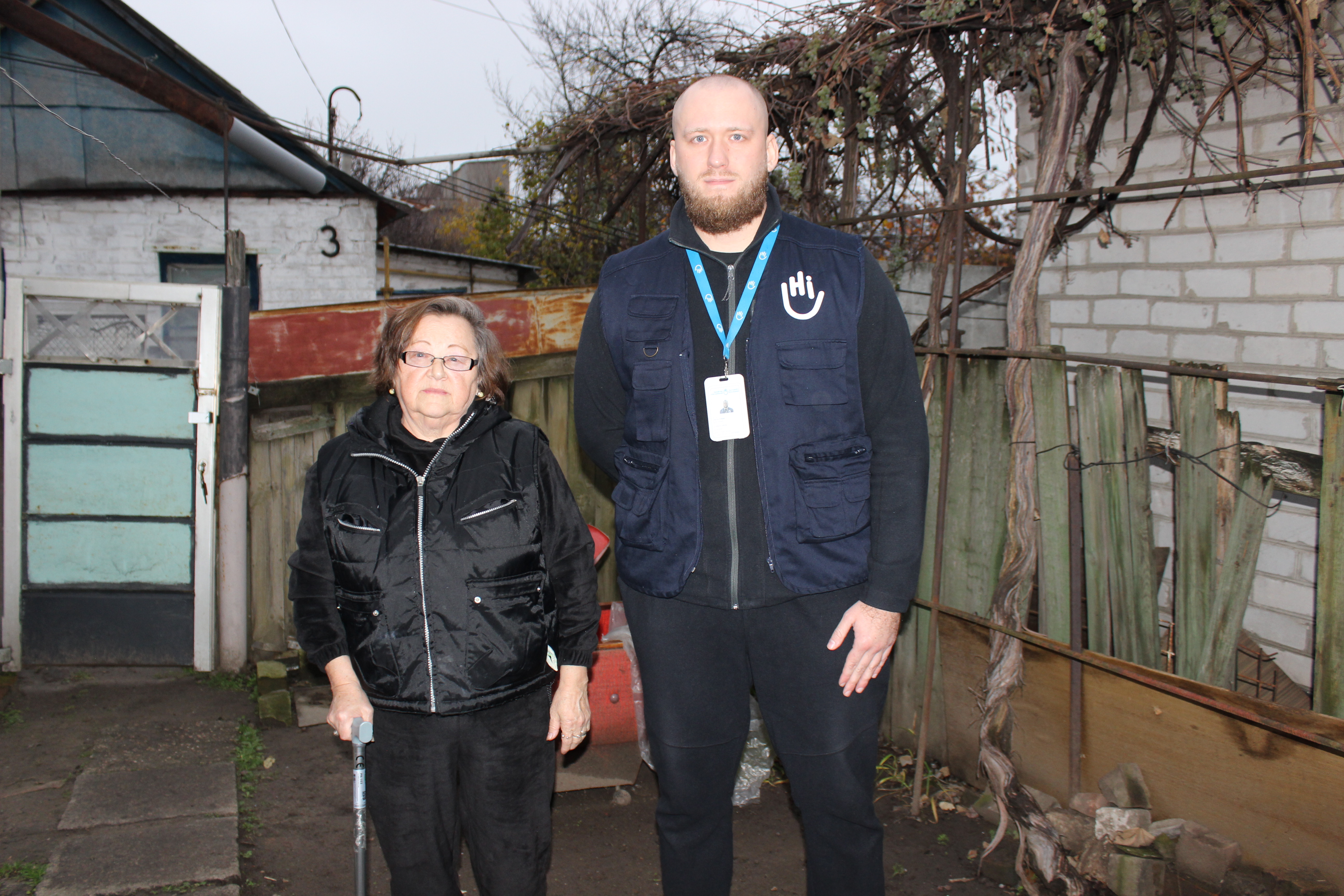 Valentyna Dukh, près de son logement fourni par la communauté, en compagnie d'Artur Chumak, travailleur social de HI. Dnipro, novembre 2025