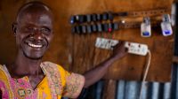 Ali est aveugle. Il charge des téléphones dans le magasin qu'il possède avec sa femme Abiba, également aveugle, à Kakuma Ville, au Kenya. Ali et Abiba viennent toutes deux de Kakuma et ont reçu le soutien d’Humanité & Inclusion et d'autres ONG pour leur boutique après l'arrivée des ONG pour soutenir l'afflux de réfugiés. 