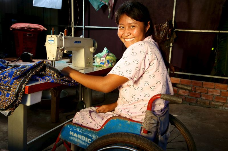 Une jeune fille en chaise roulante faisant de la couture