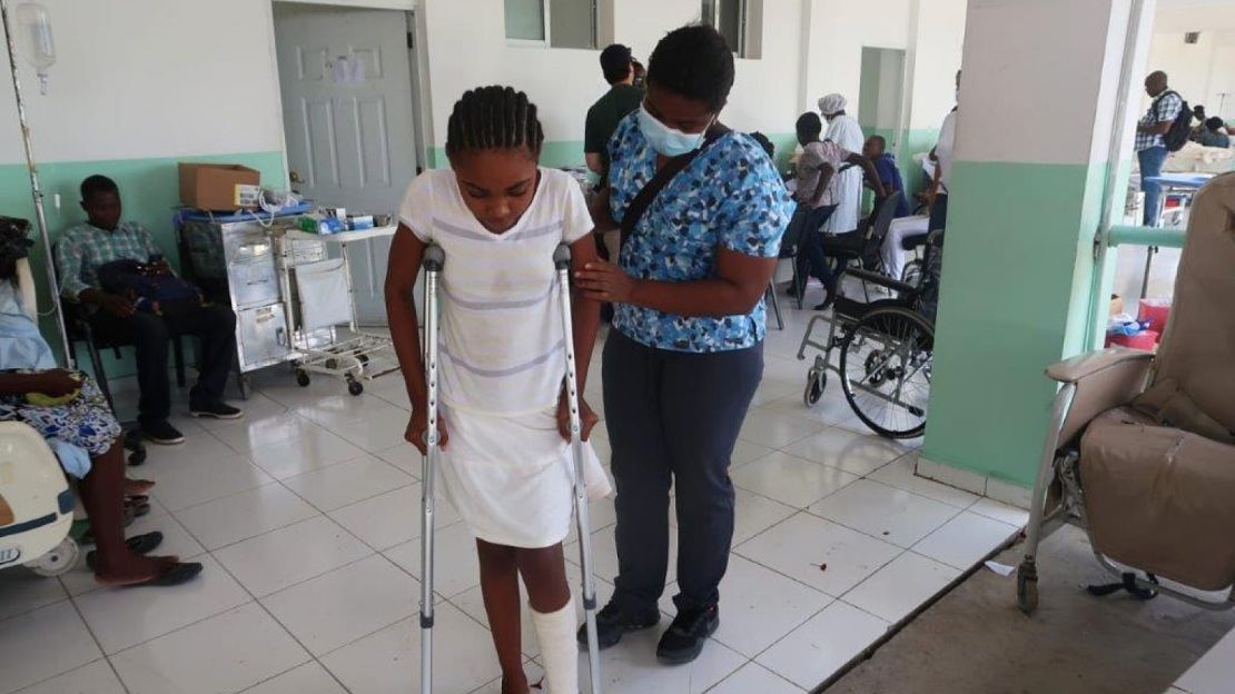 Après une fracture causée par le tremblement de terre, Stéphanie apprend à marcher avec des béquilles avec la kinésithérapeute Frédia.