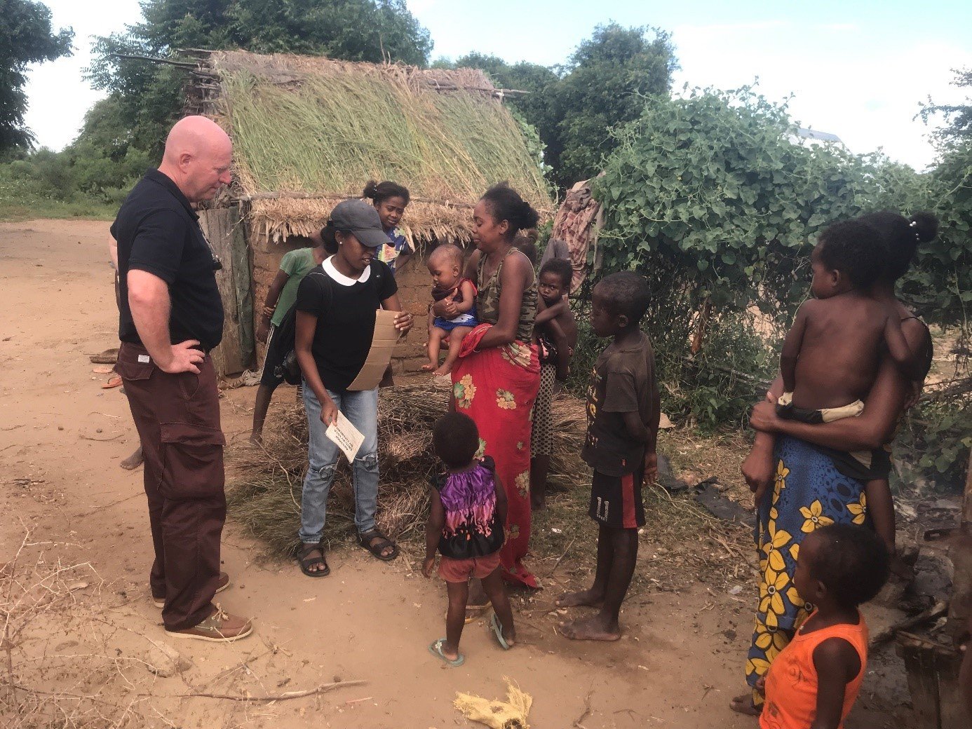 Un homme debout les mains sur les hanches discutant avec des familles