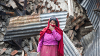 Une femme debout devant des décombres