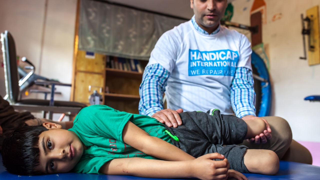 Fayaz durant une séance de réadaptation avec Muddasir Ashraf, kinésithérapeute et Disability Manager pour Handicap International