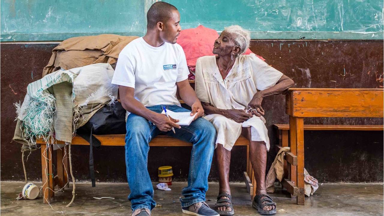 L'équipe de Handicap International avec Méralia Simon, 90 ans, qui a trouvé refuge au lycée Philippe Guerrier, aux Cayes. 