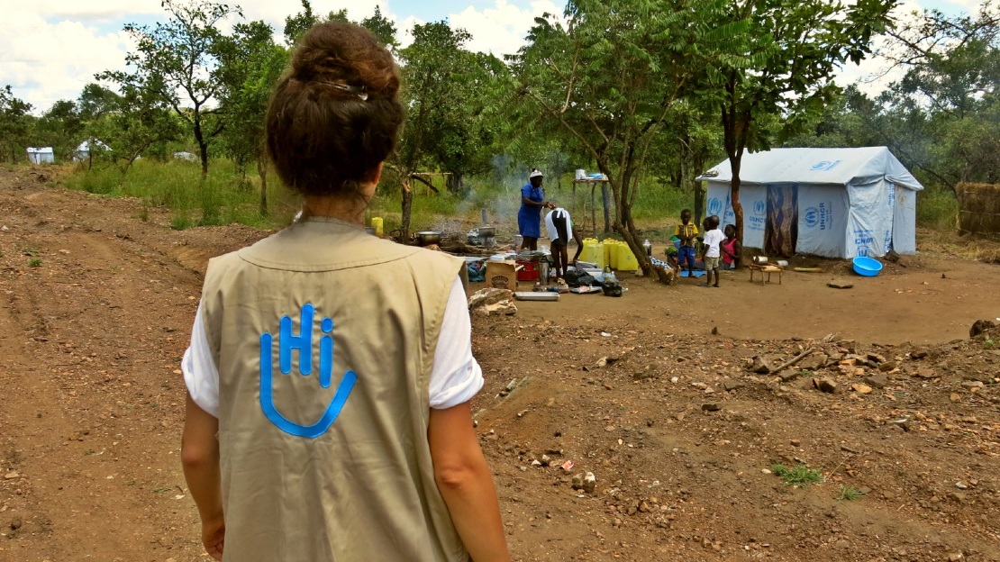 Une coordinatrice terrain avec une famille dans un camp de réfugiés en Ouganda