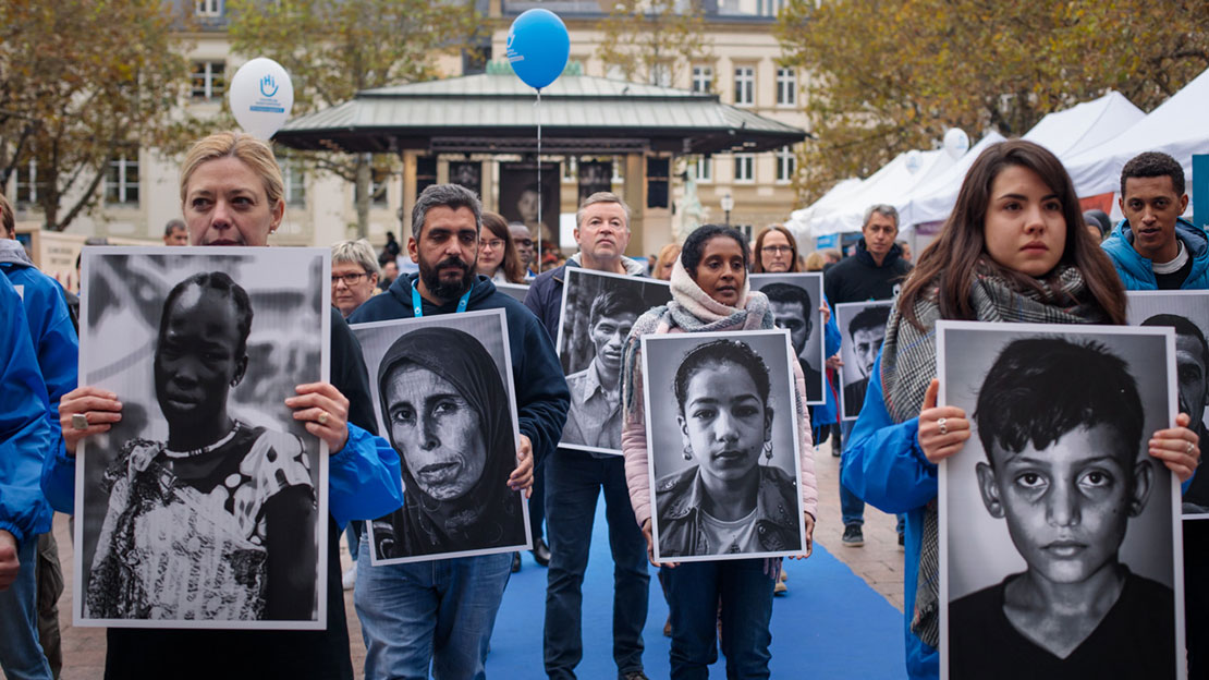 Lors d’un flashmob, les bénévoles de l’ONG ont défilé en brandissant le portrait d’un bénéficiaire de Handicap International victime de bombardement.