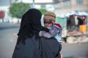 Une mère porte son enfant à Sana'a 