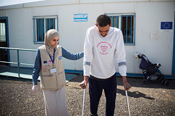 Mohammed, avec une kiné de Handicap International, pendant une session de réadaptation dans le centre d'Azraq, en Jordanie.